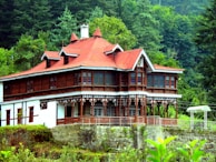 A large wooden house sitting on top of a lush green hillside
