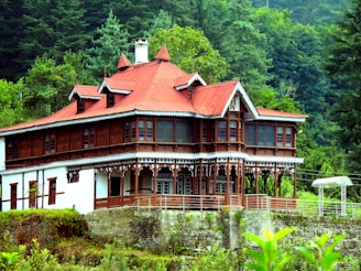A large wooden house sitting on top of a lush green hillside