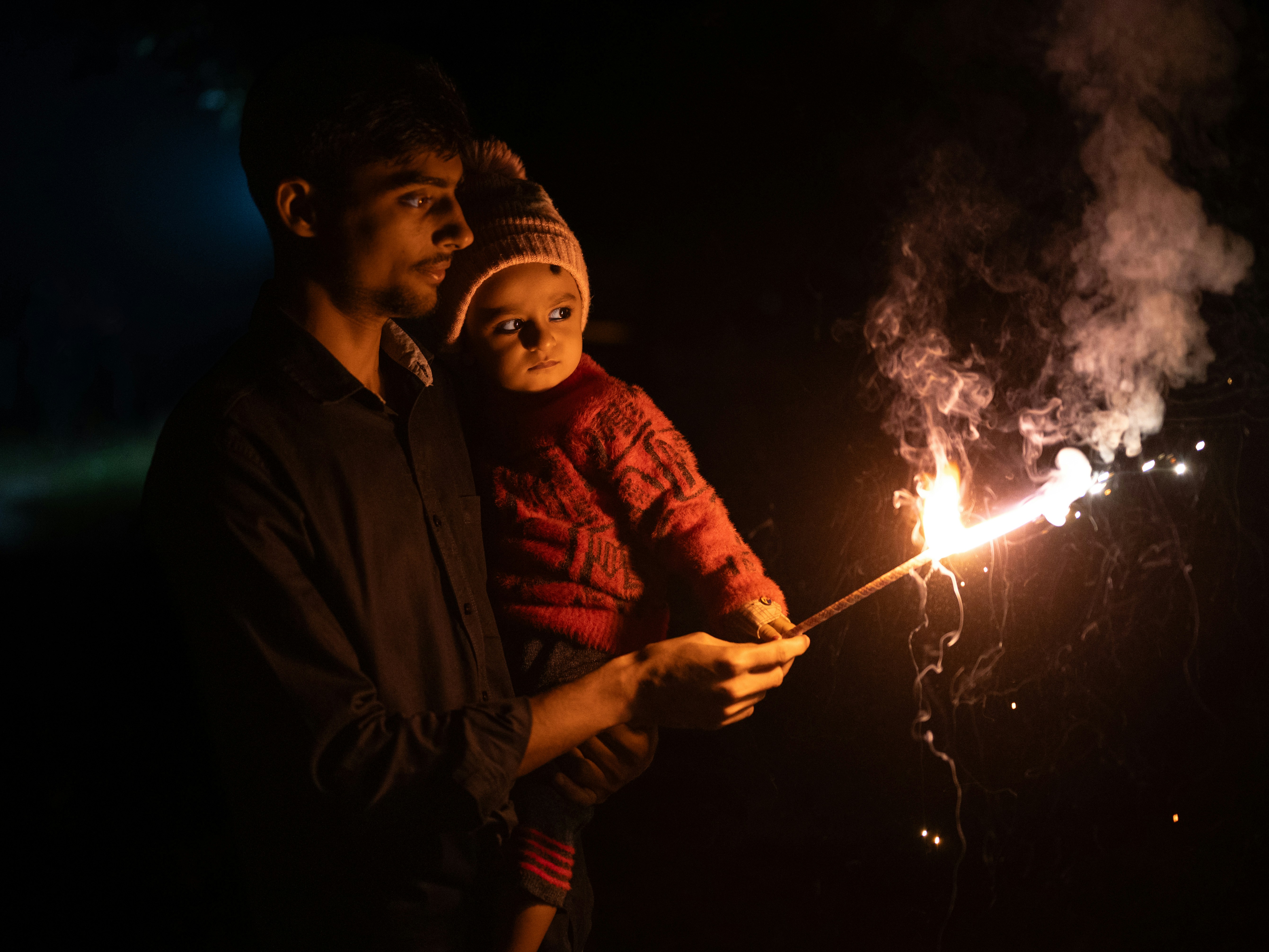 A man and a child holding a sparkler