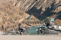 A group of motorcycles parked next to a river
