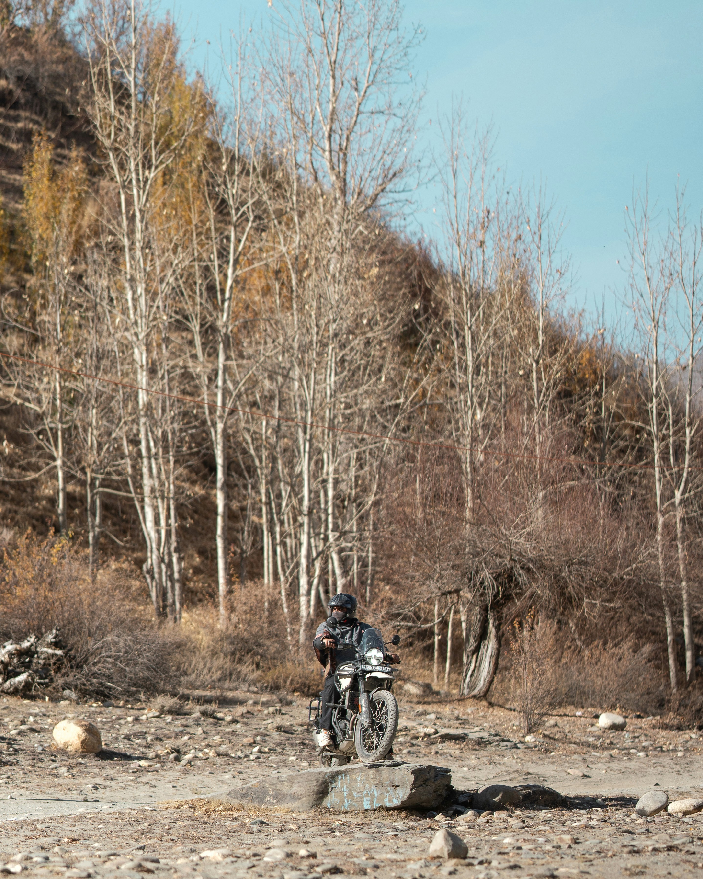 A man riding a motorcycle down a dirt road