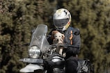 A person on a motorcycle with a dog