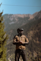 A man wearing a helmet standing on a rock