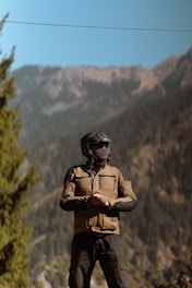 A man wearing a helmet standing on a rock