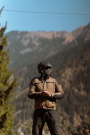 A man wearing a helmet standing on a rock