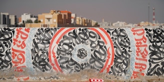 A wall covered in graffiti in front of a city