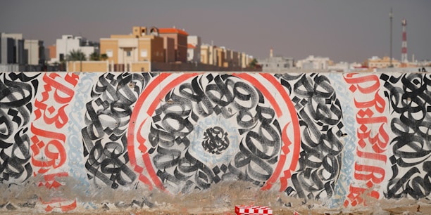 A wall covered in graffiti in front of a city