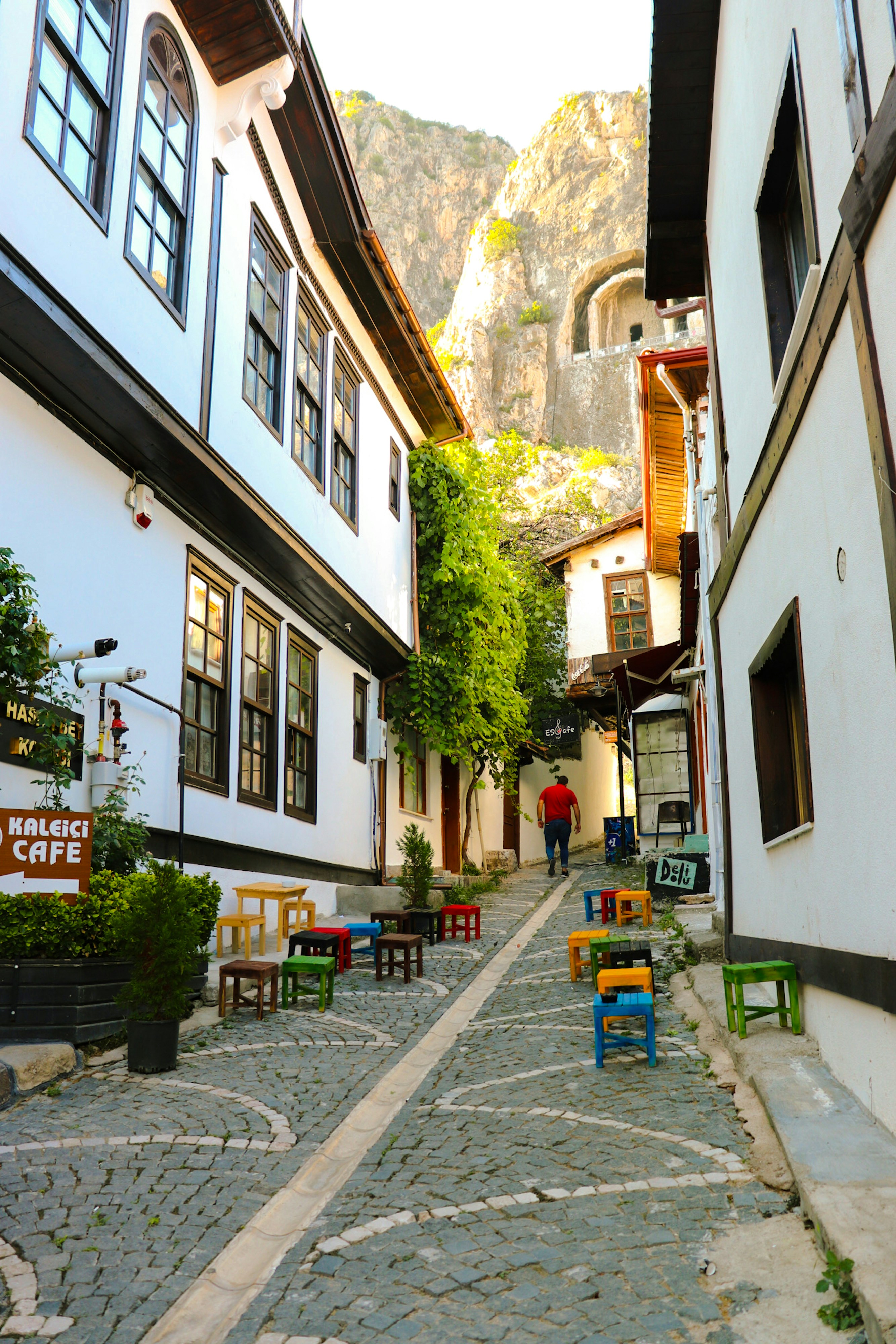 A narrow cobblestone street with tables and chairs