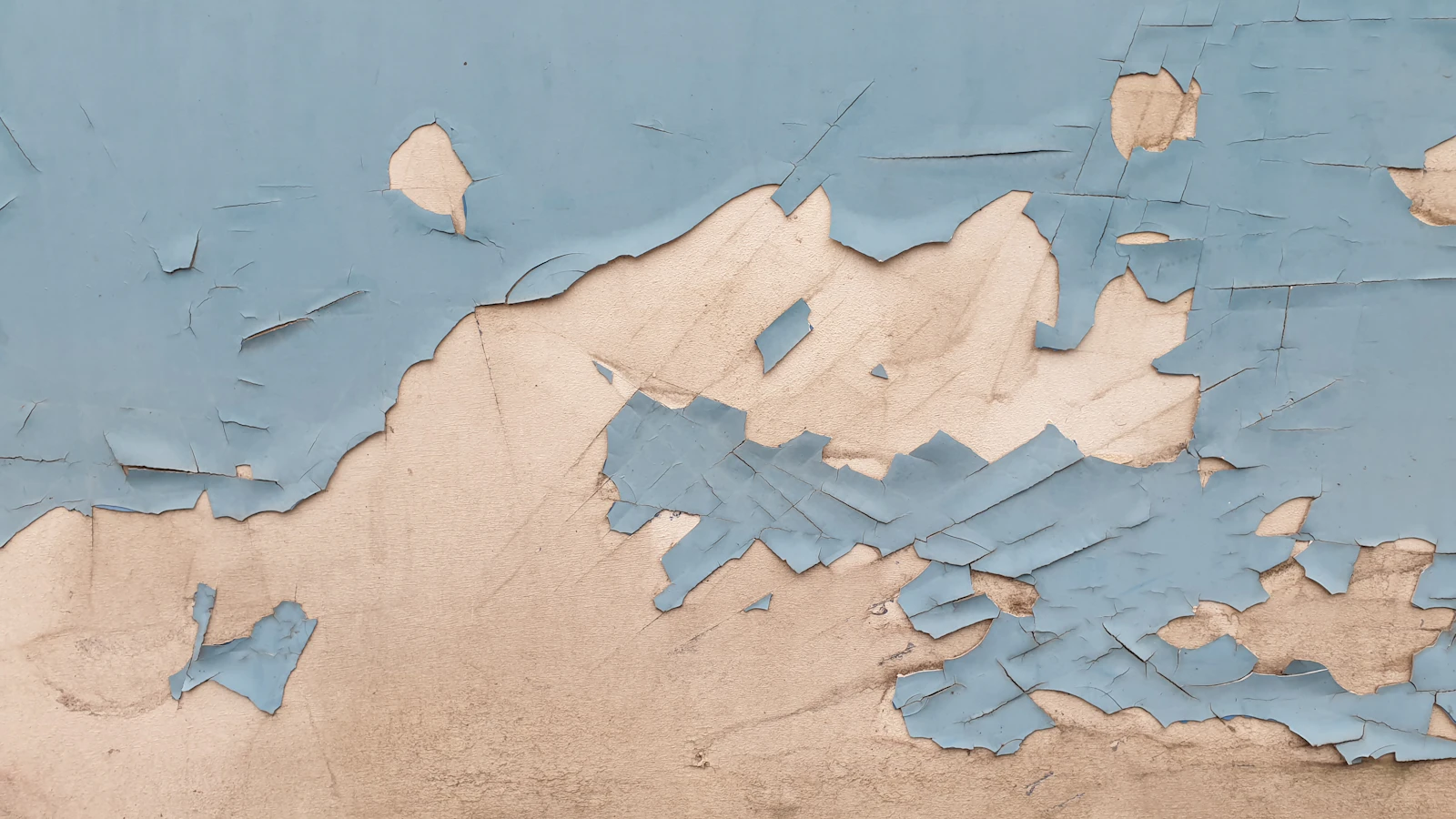 A wall with old, peeling and flaking paint