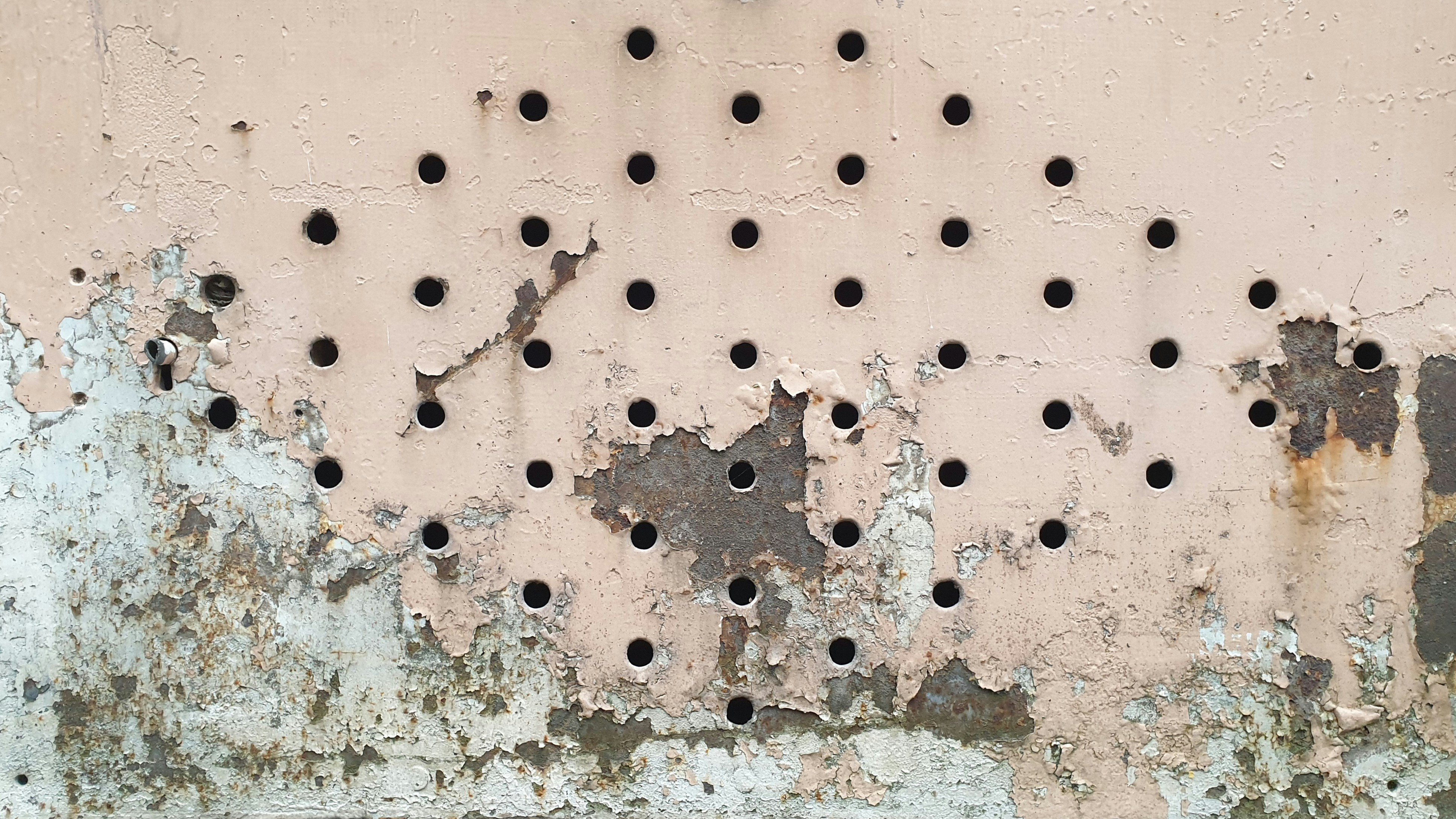 A rusted wall with holes in it