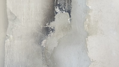 A white wall with peeling paint on it