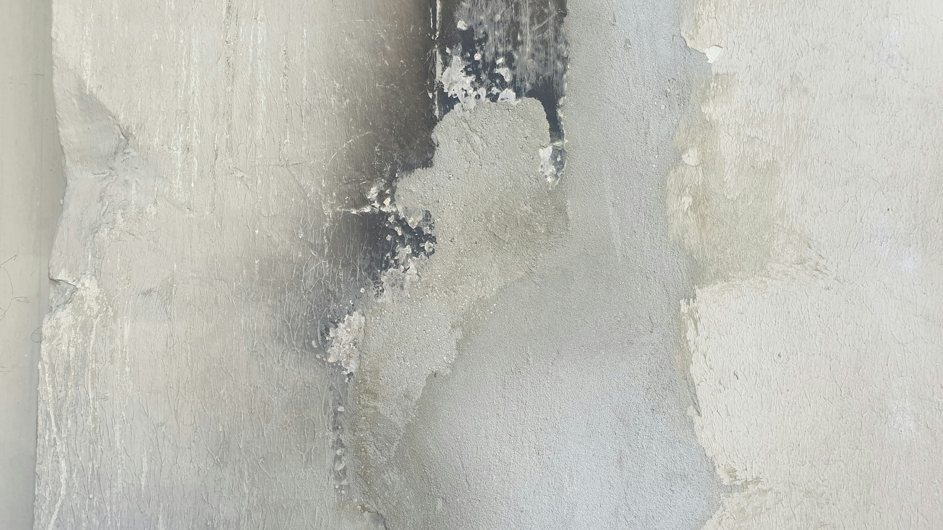 A white wall with peeling paint on it