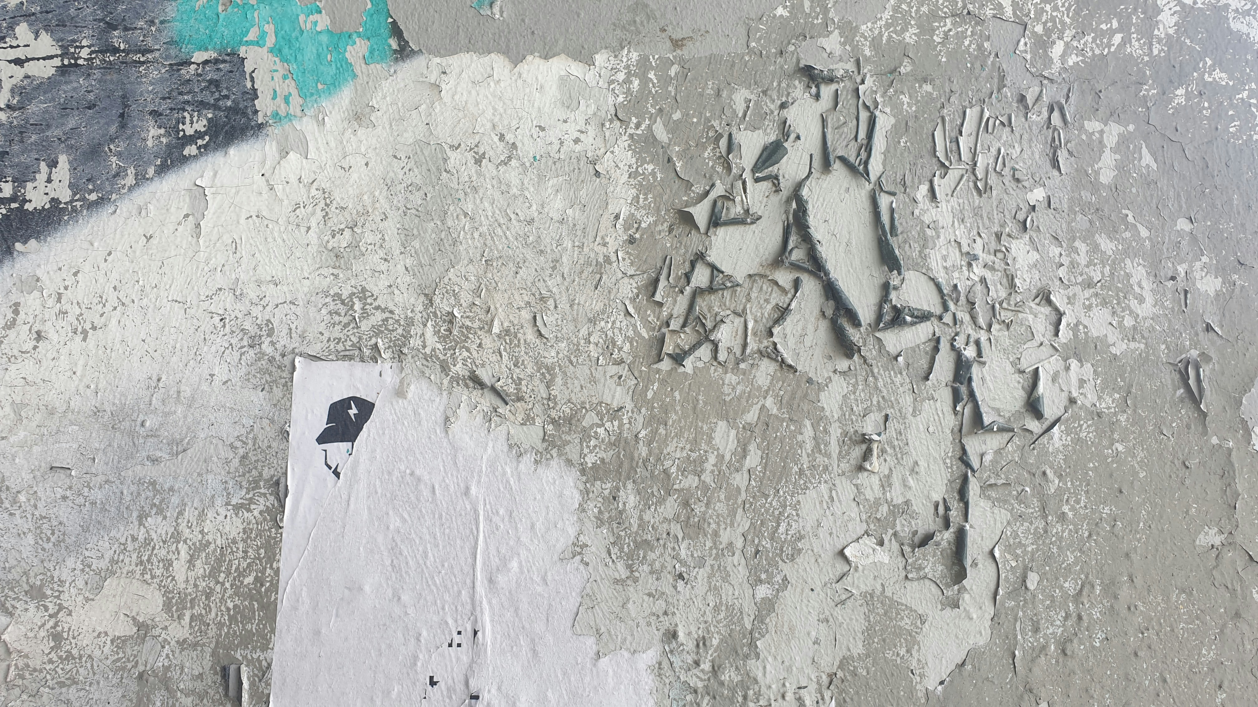 A white wall with a blue and green painting on it