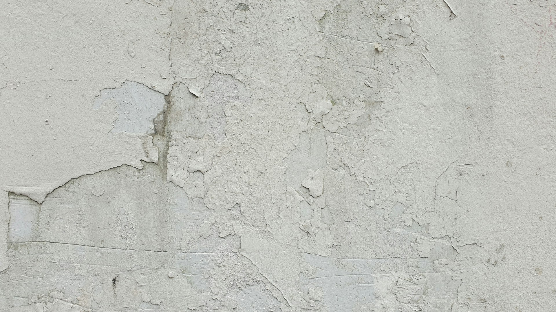 A white wall with peeling paint on it