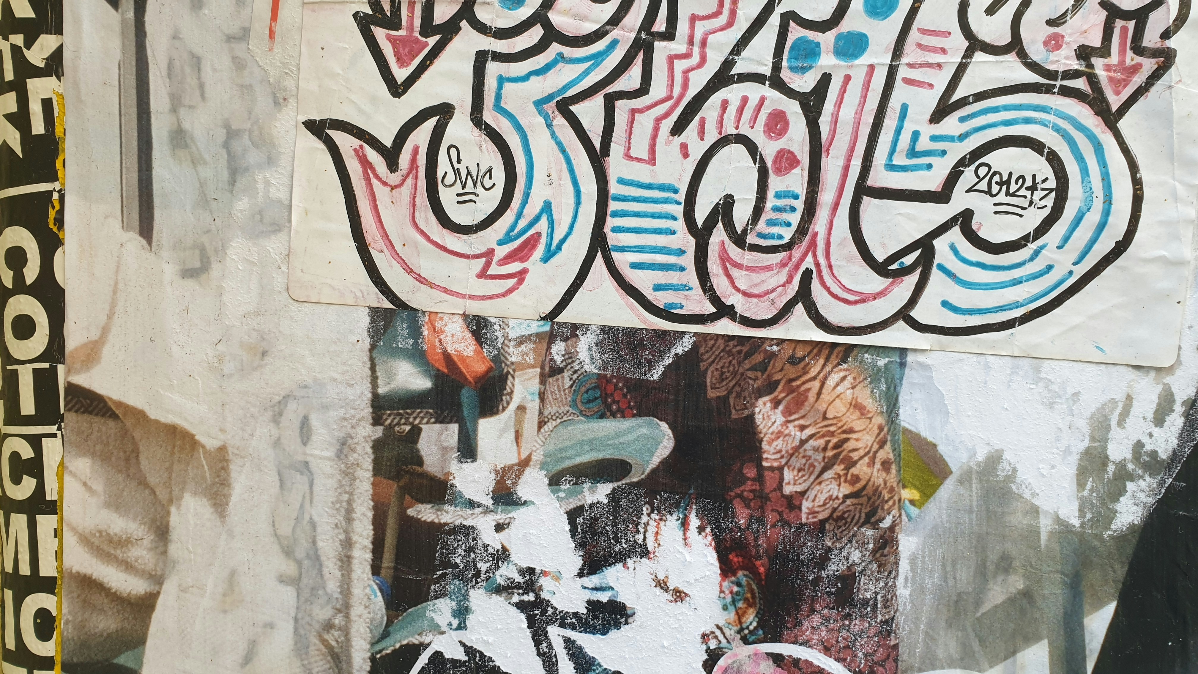 Un hombre de pie junto a una pared cubierta de grafitis