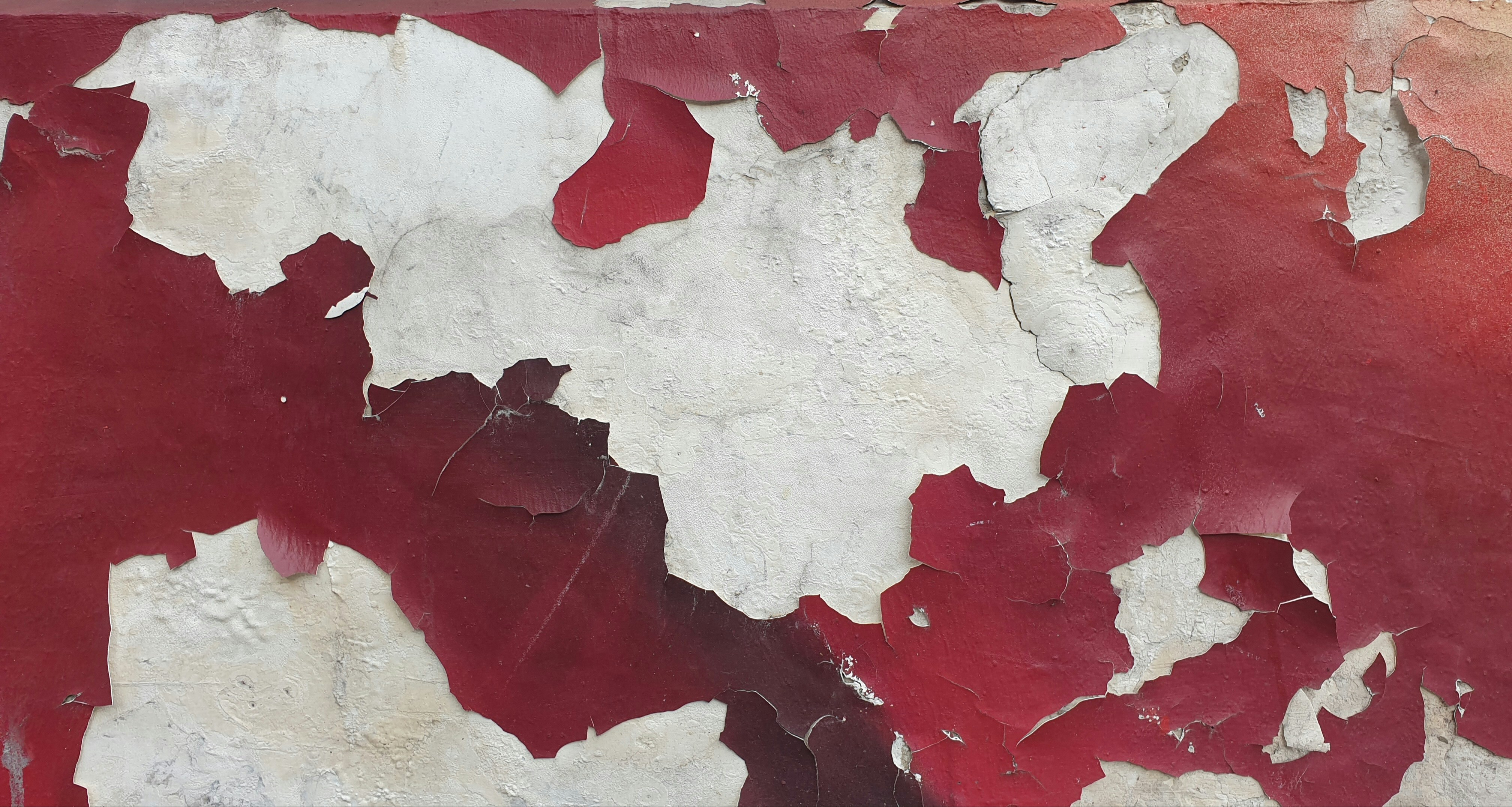 Una pared roja y blanca con pintura descascarada