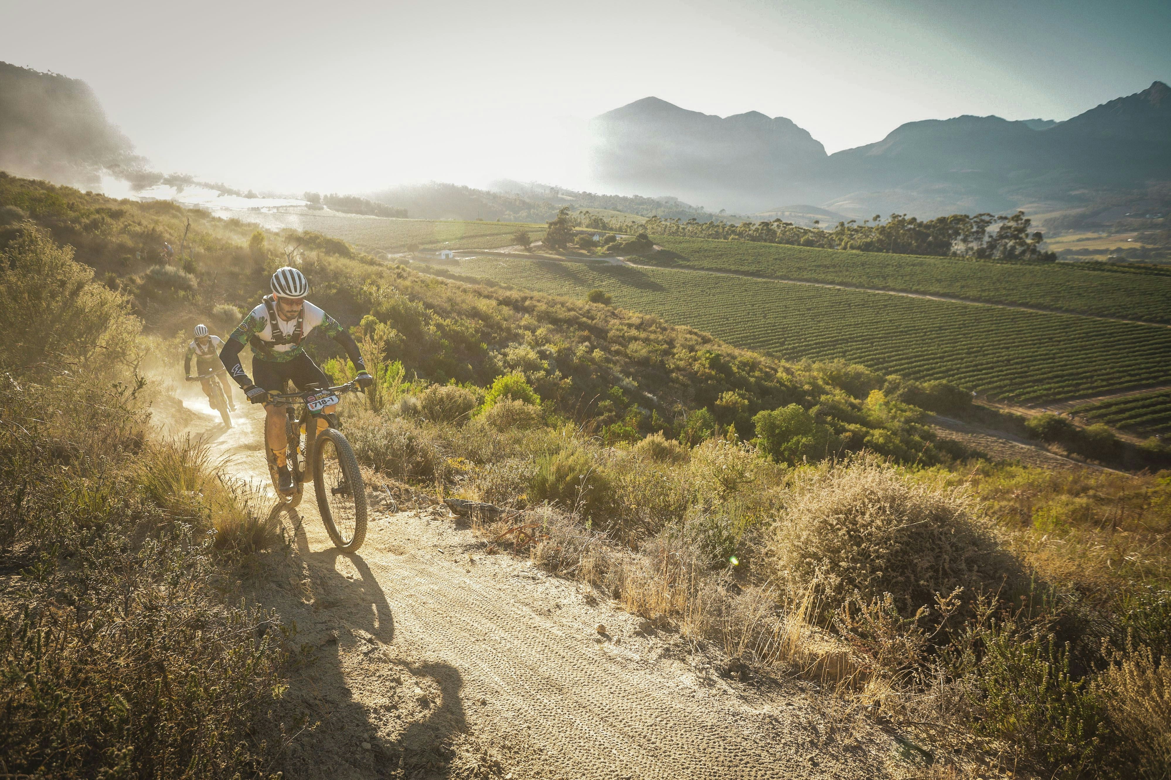 A man riding a bike down a dirt road