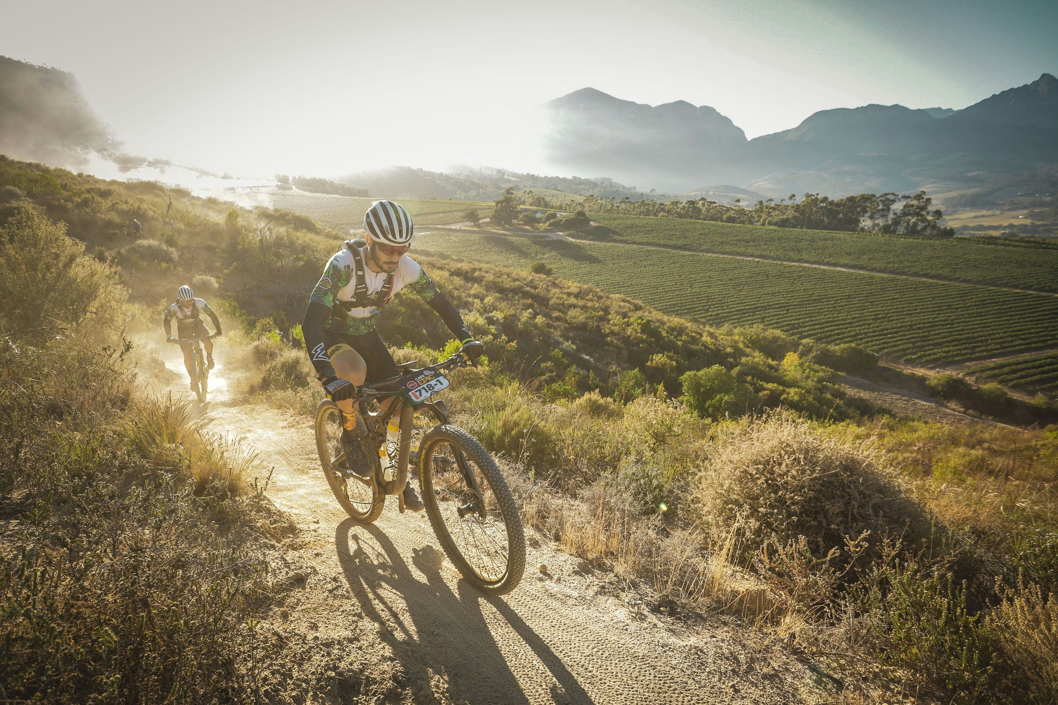 A man riding a bike down a dirt road