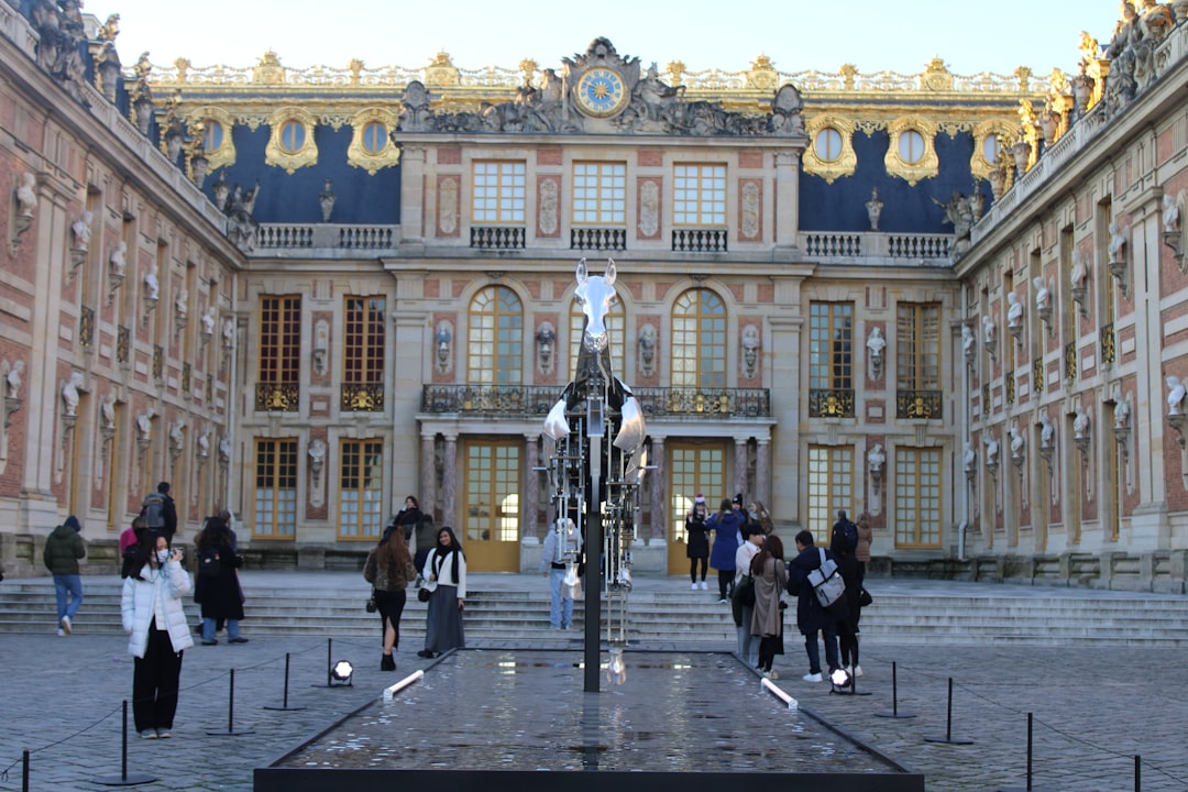 A group of people walking in front of a building, Le cheval de Fer des jeux Olympiques de 2024, A Versailles.