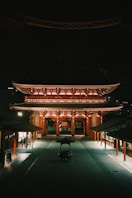 A dark street with a building lit up at night
