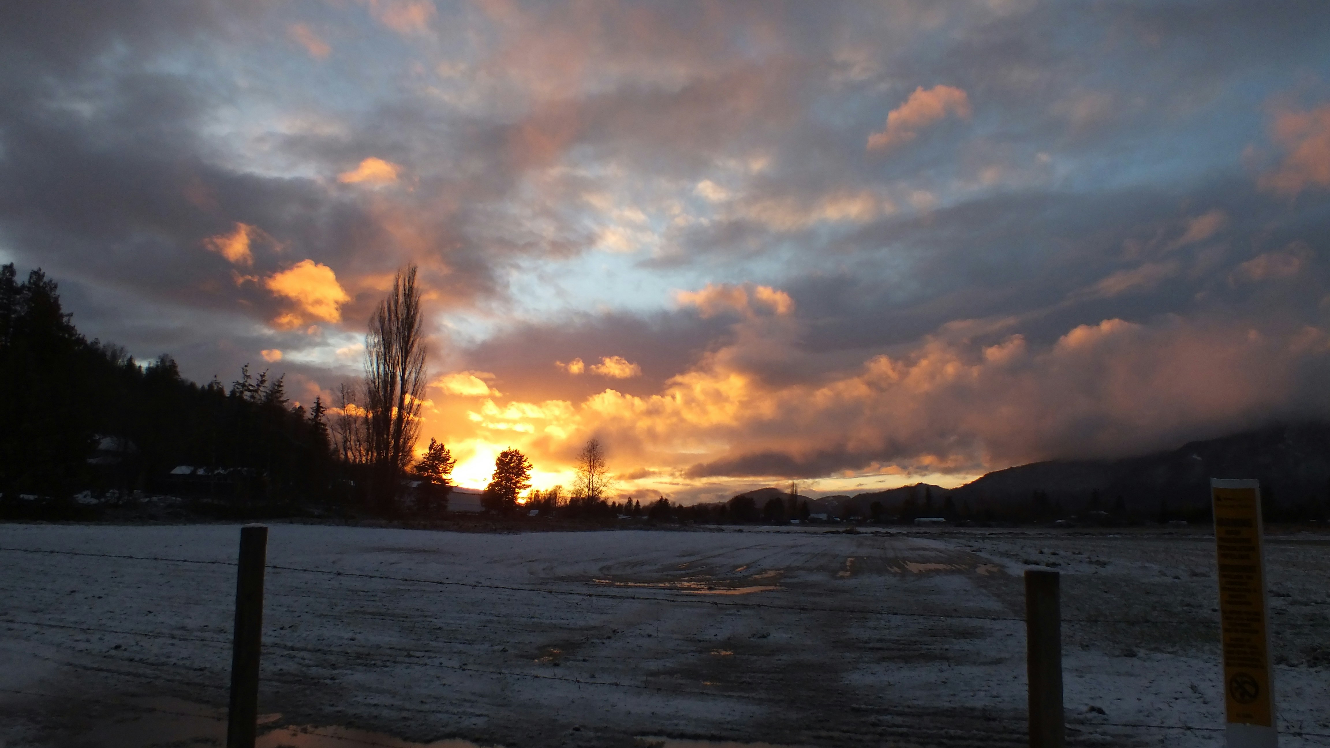 The sun is setting over a frozen lake
