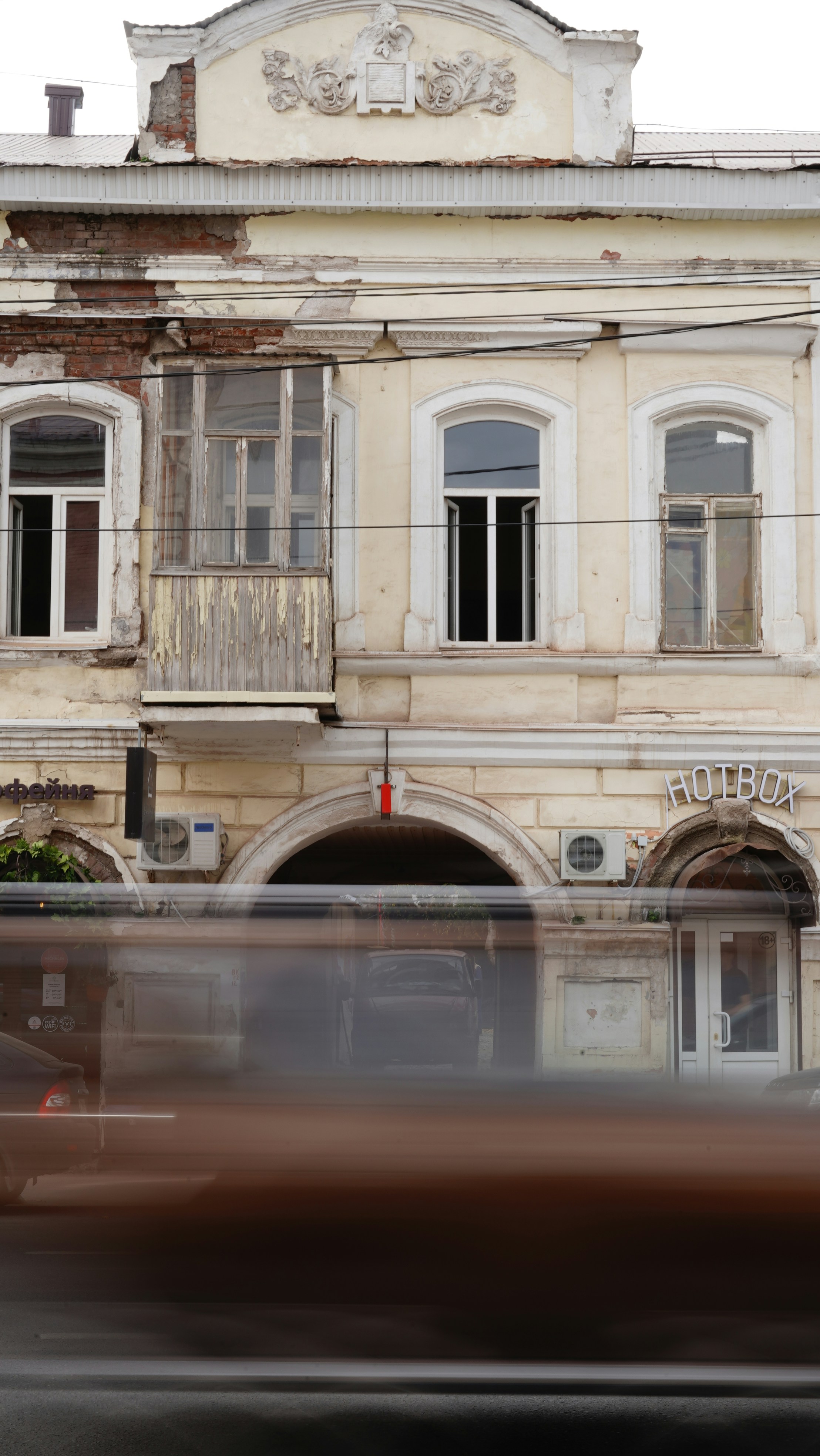 Ein verschwommenes Foto eines alten Gebäudes mit einem vorbeifahrenden Bus