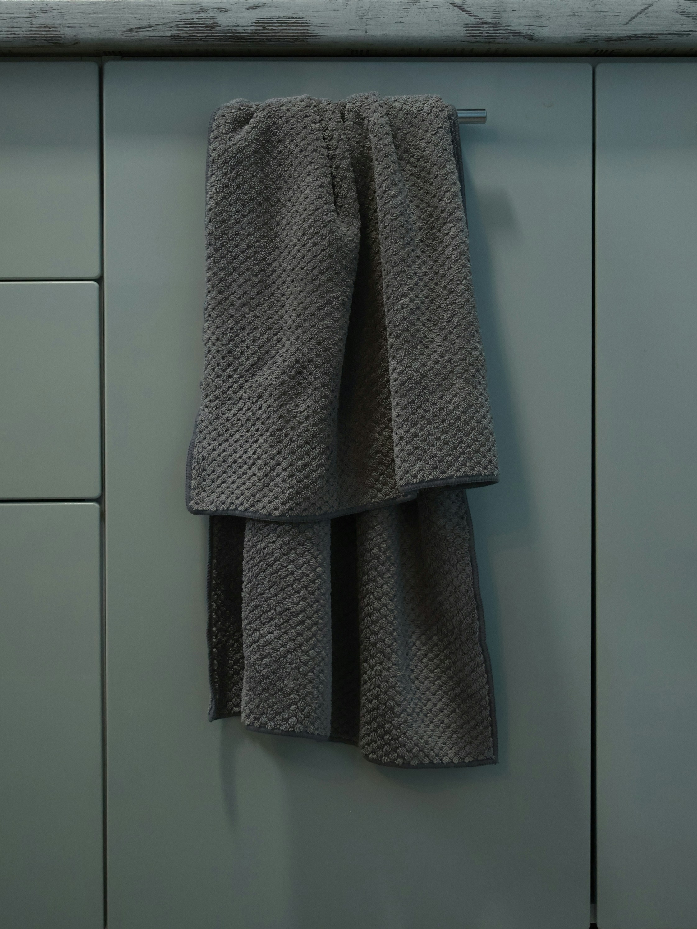 A towel hanging on a cabinet in a kitchen