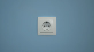 A white electrical outlet on a blue wall