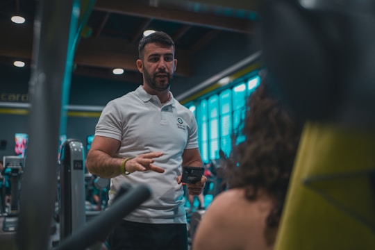 A man in a white shirt is standing in a gym
