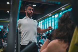 A man in a white shirt is in a gym