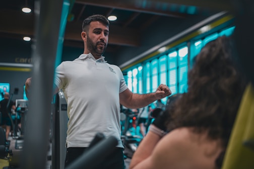 A man in a white shirt is in a gym