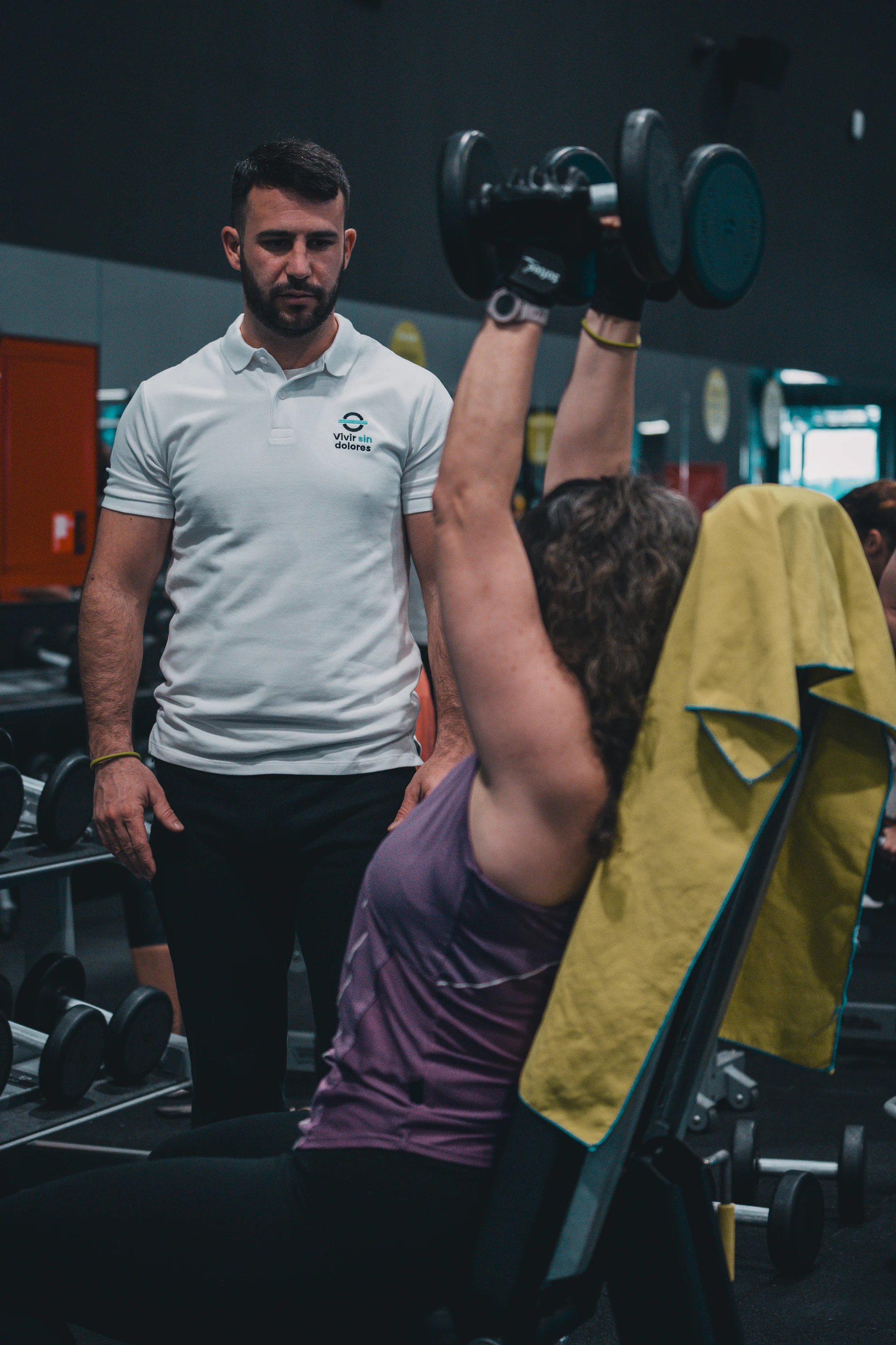 Barbell loaded with weight plates mid-lift in a training facility