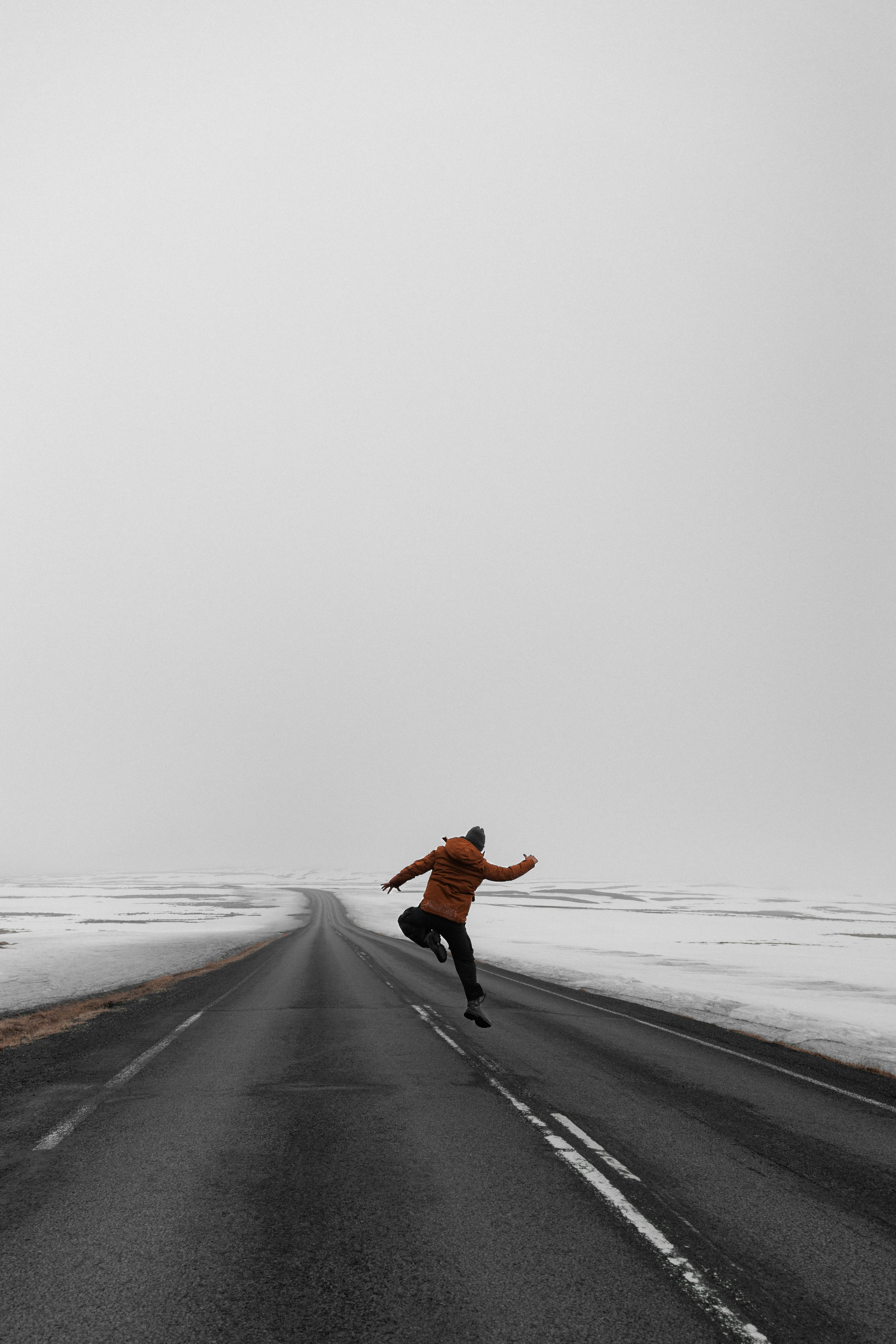 A man is running down a snowy road