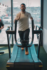 A man standing on a treadmill in front of a window