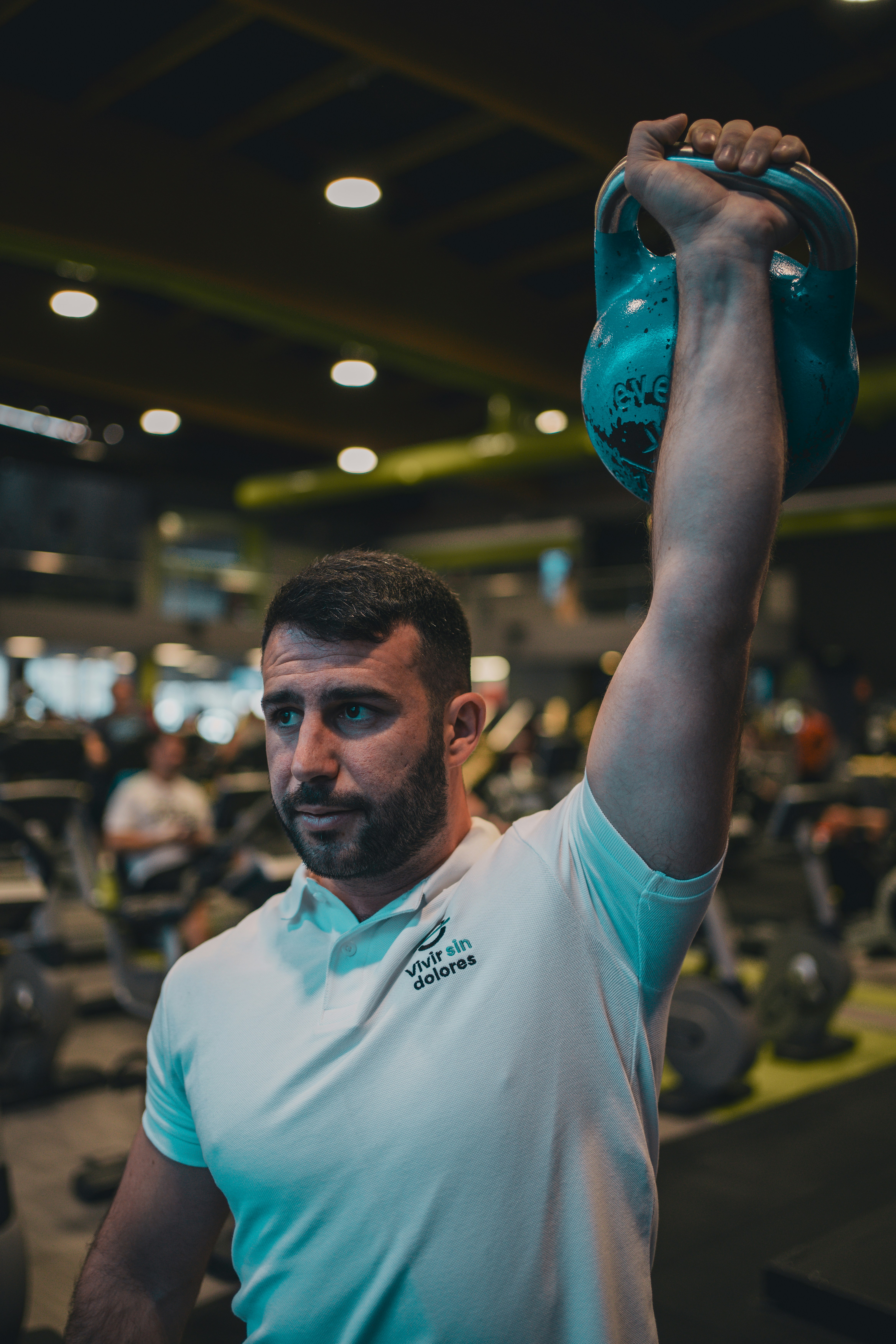 A man lifting a kettle in a gym