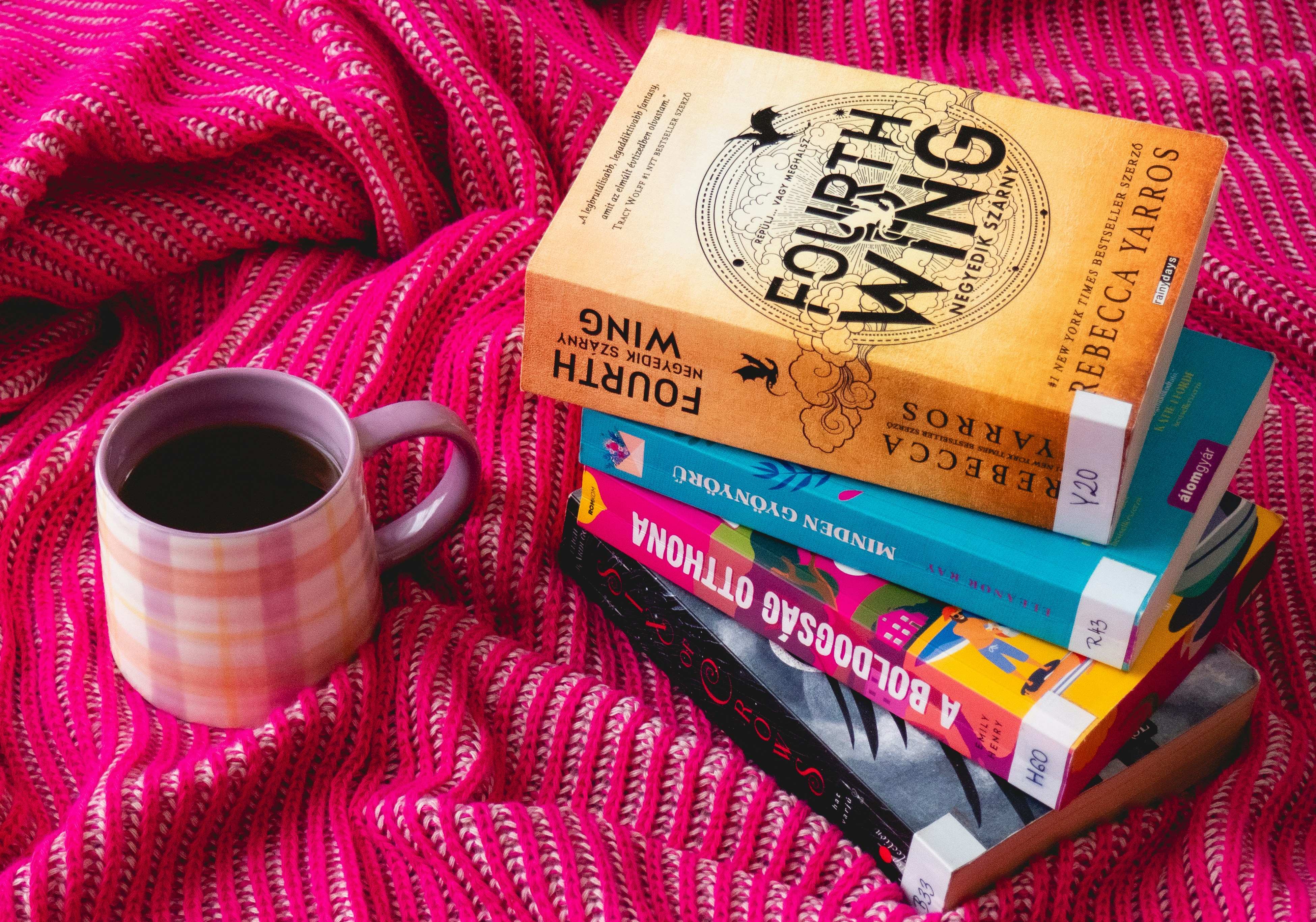 A stack of books sitting next to a cup of coffee