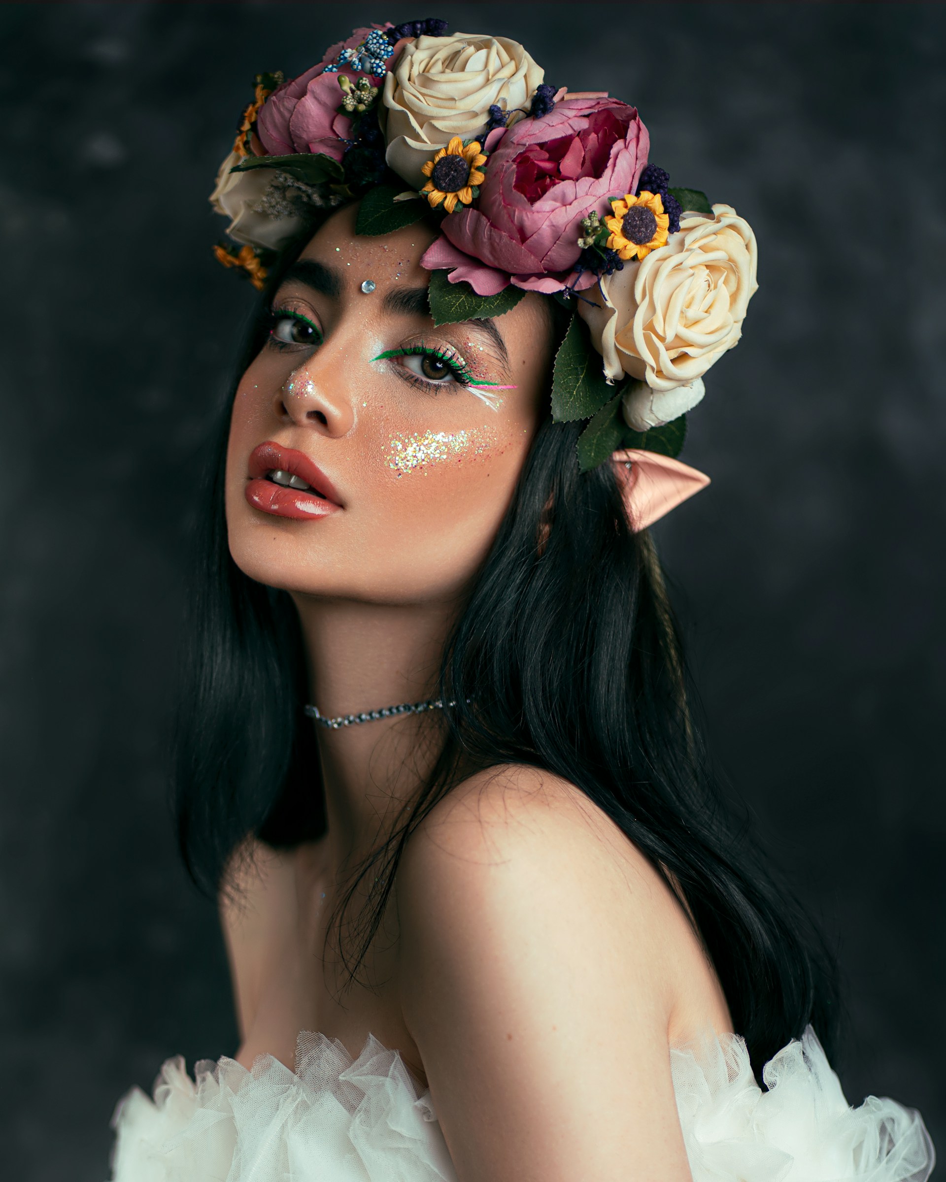 A woman with flowers in her hair and makeup