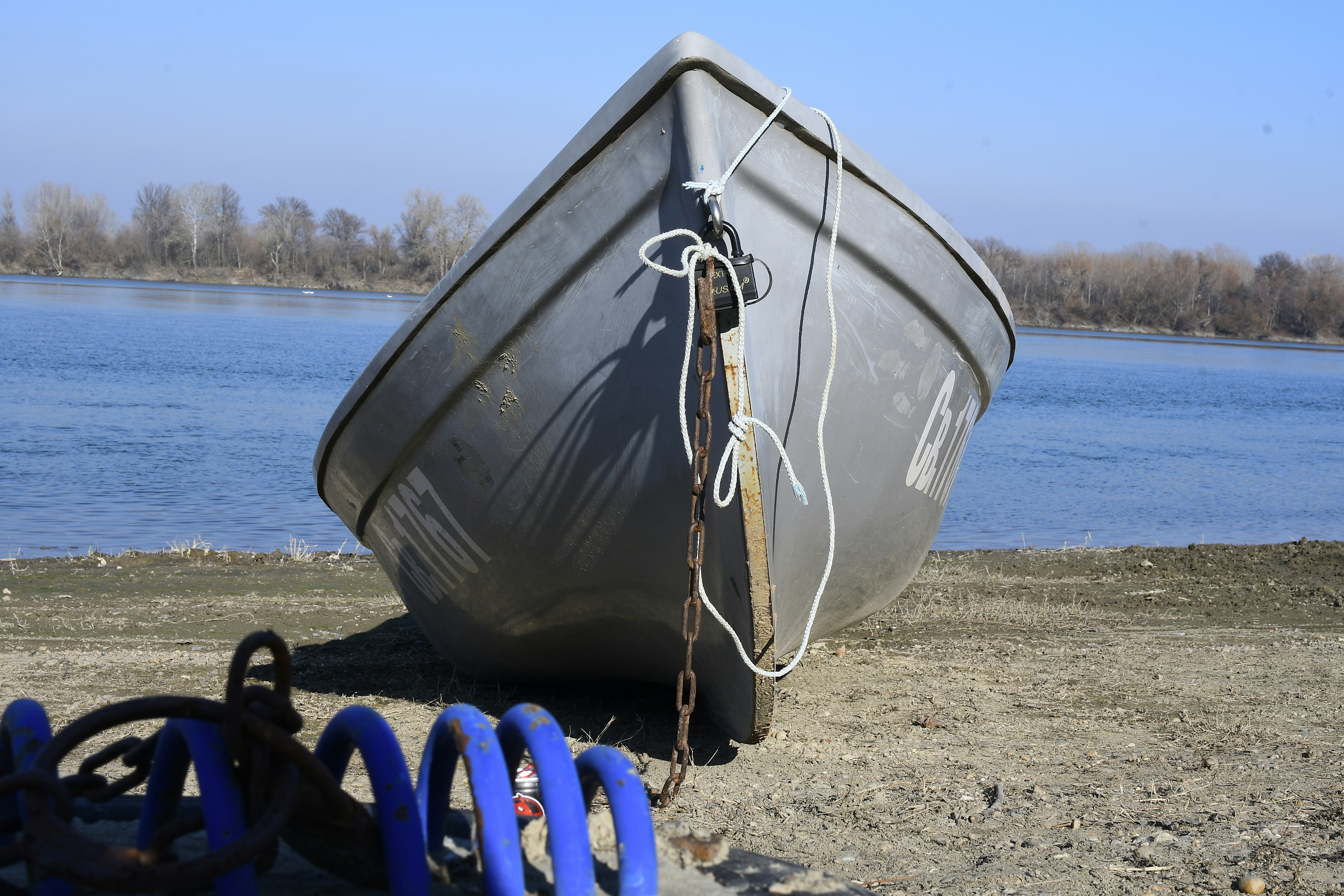 A boat sitting on top of a beach next to a body of water