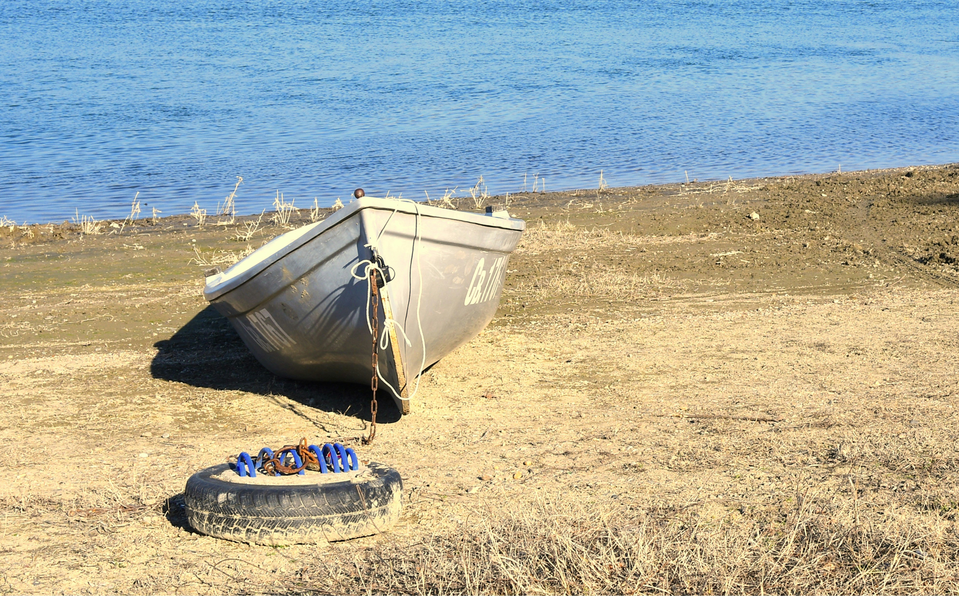 A boat sitting on top of a dry grass field