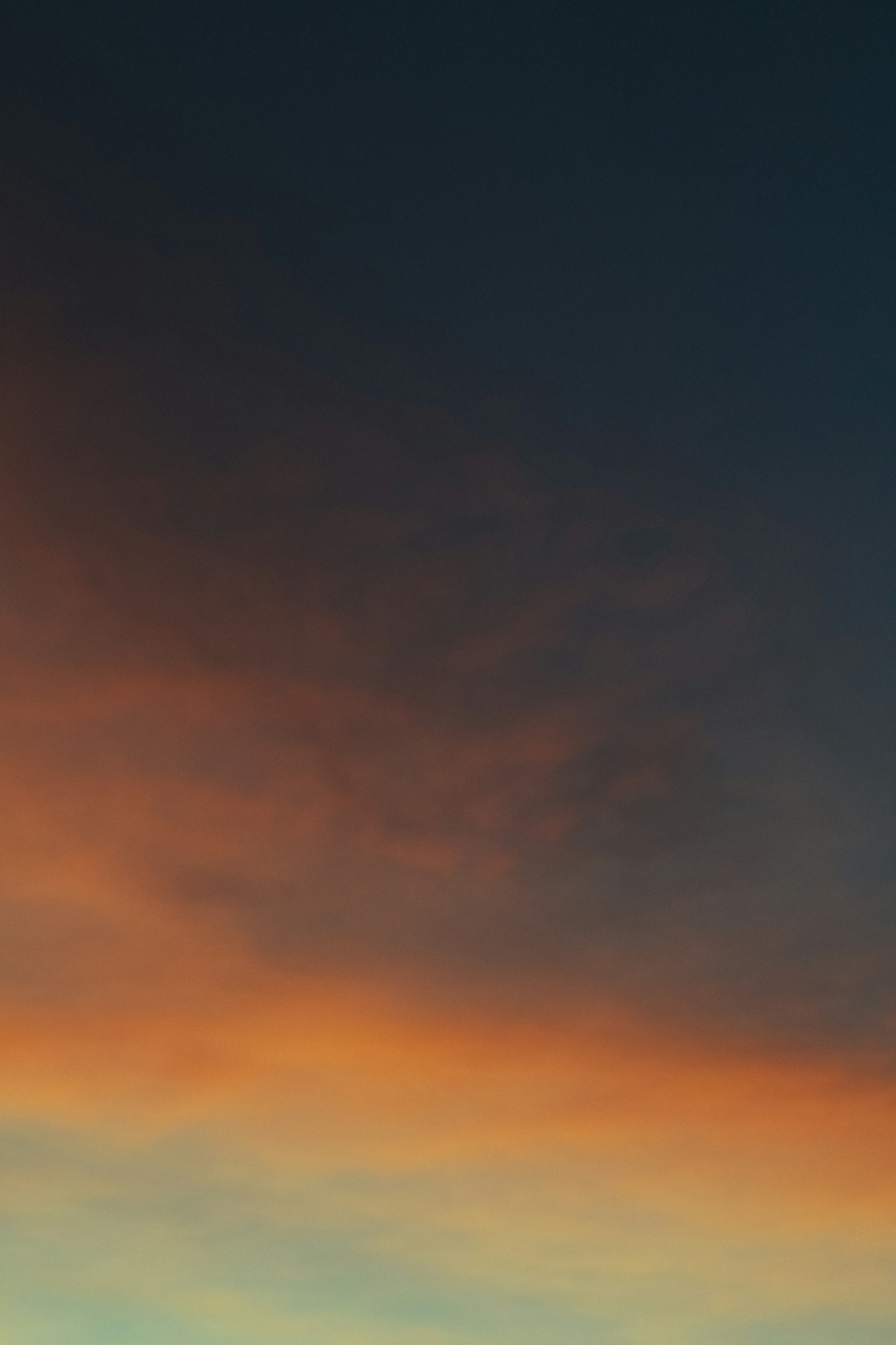 A plane flying in the sky at sunset