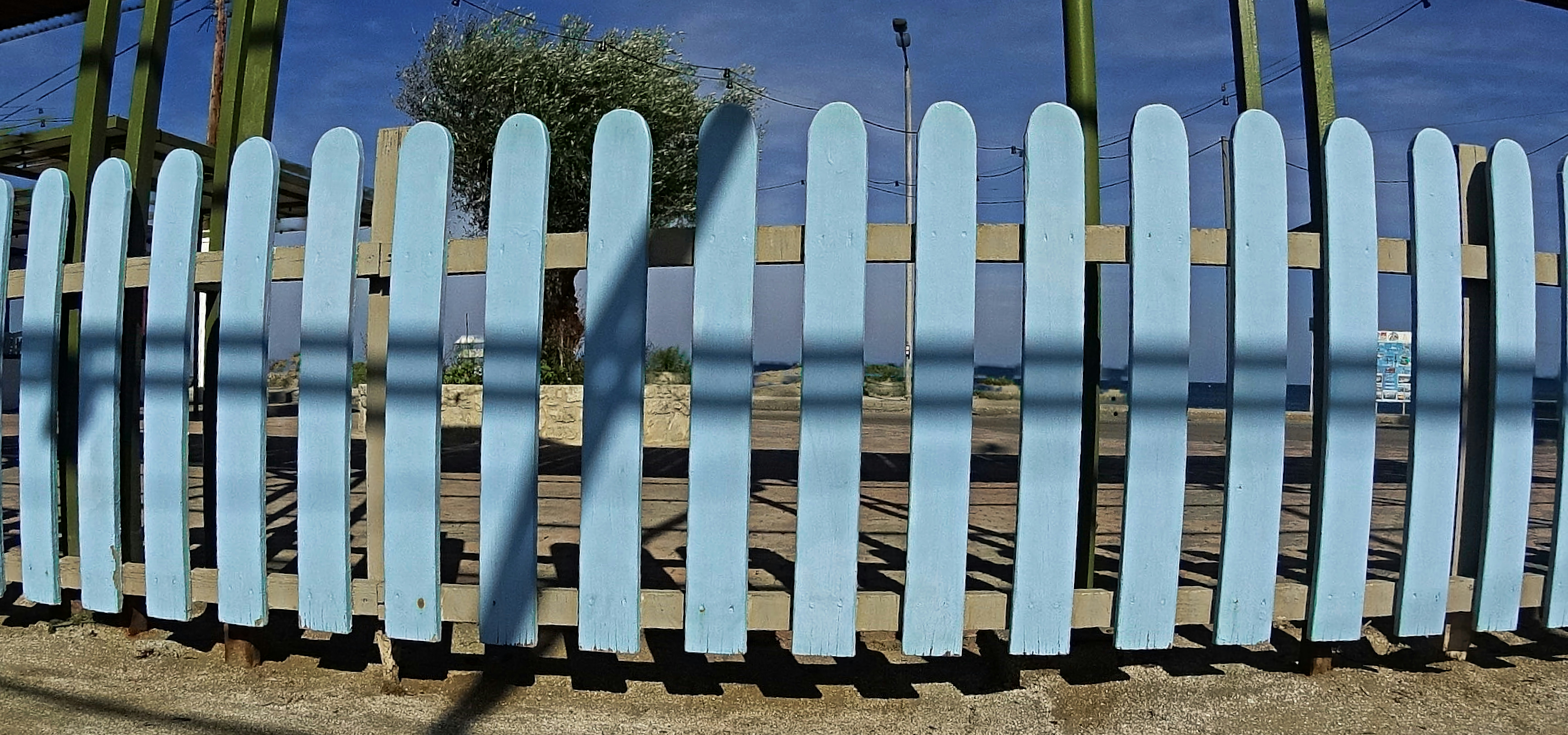 A blue bench sitting on top of a sandy beach
