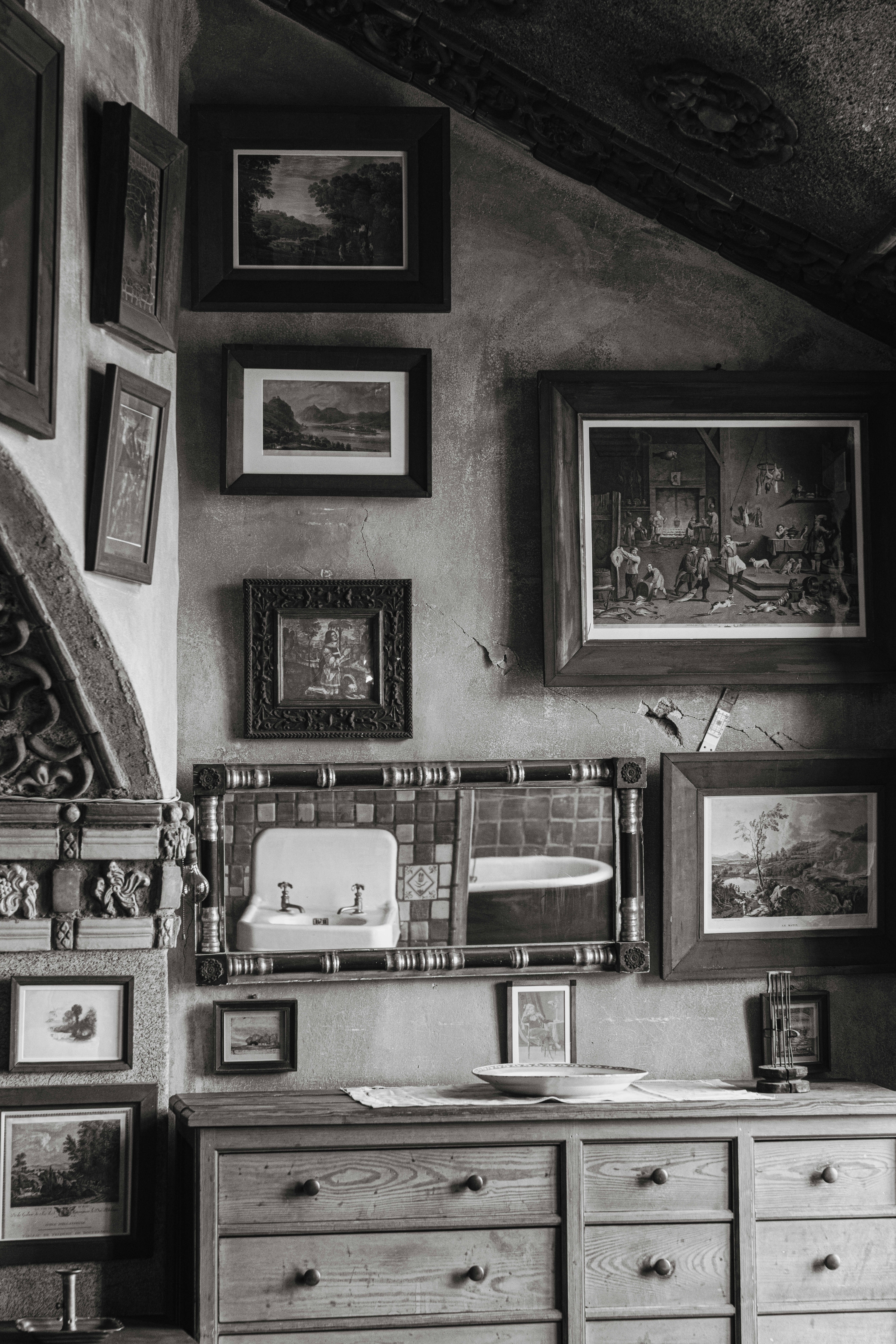 A white sink sits beneath art on a gallery wall.