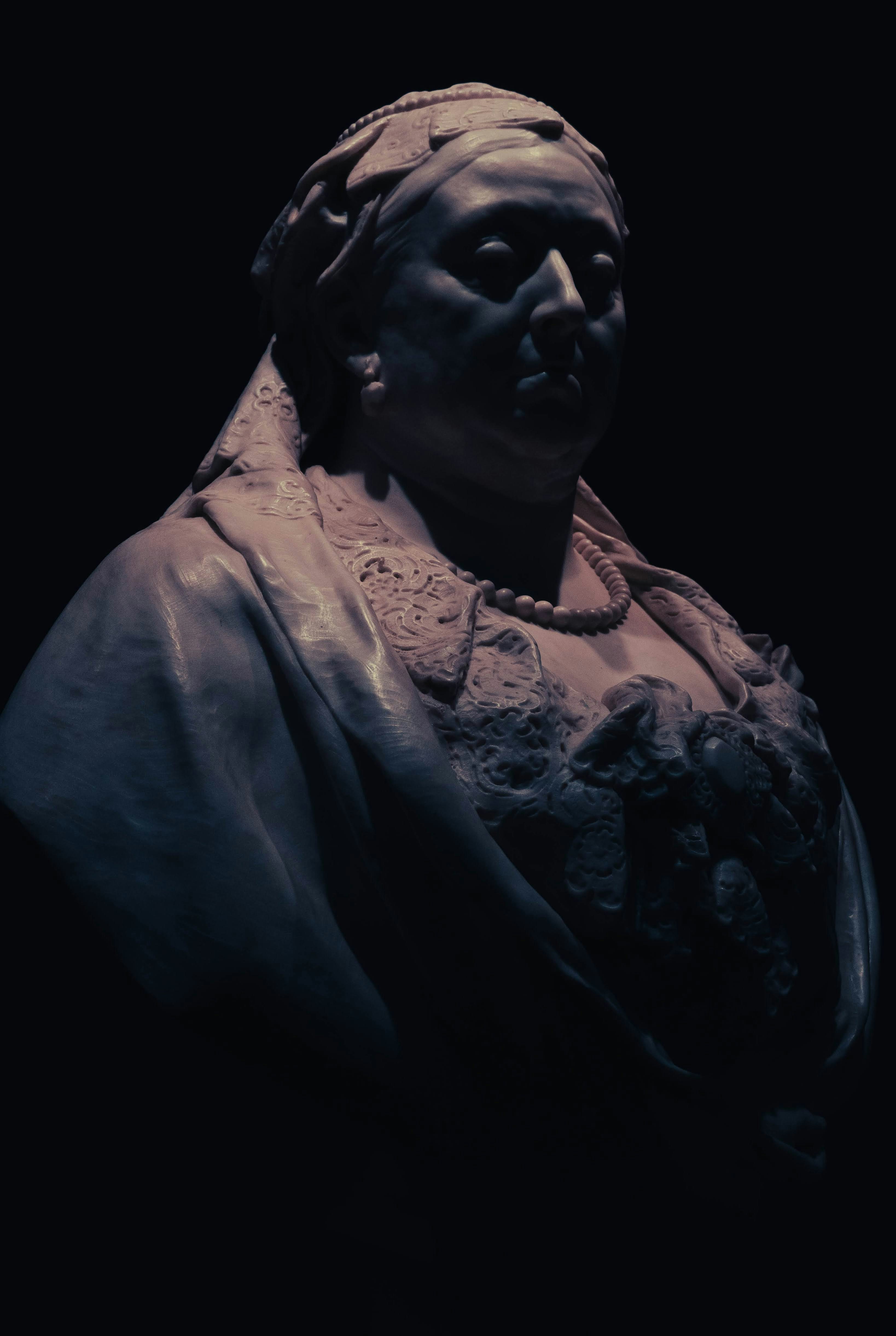 A statue of a woman with a black background