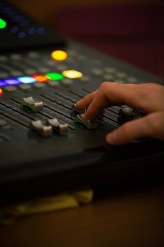 A person is pressing buttons on a sound board