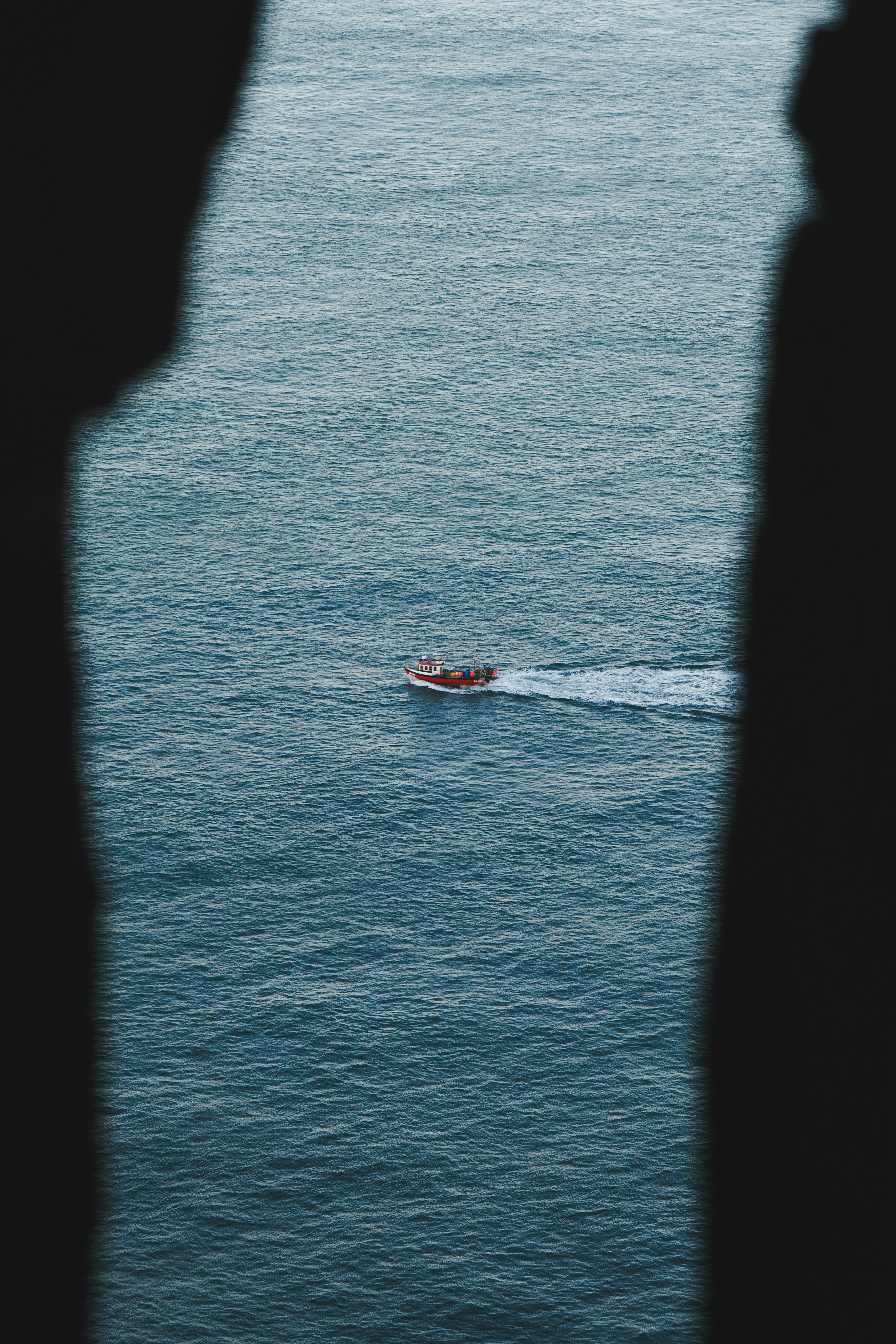 A person looking at a boat in the water