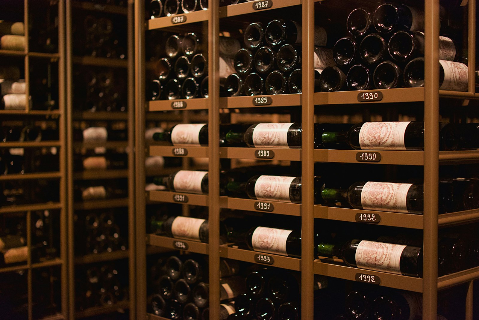 Wine cellar filled with bottles of wine on wooden shelves