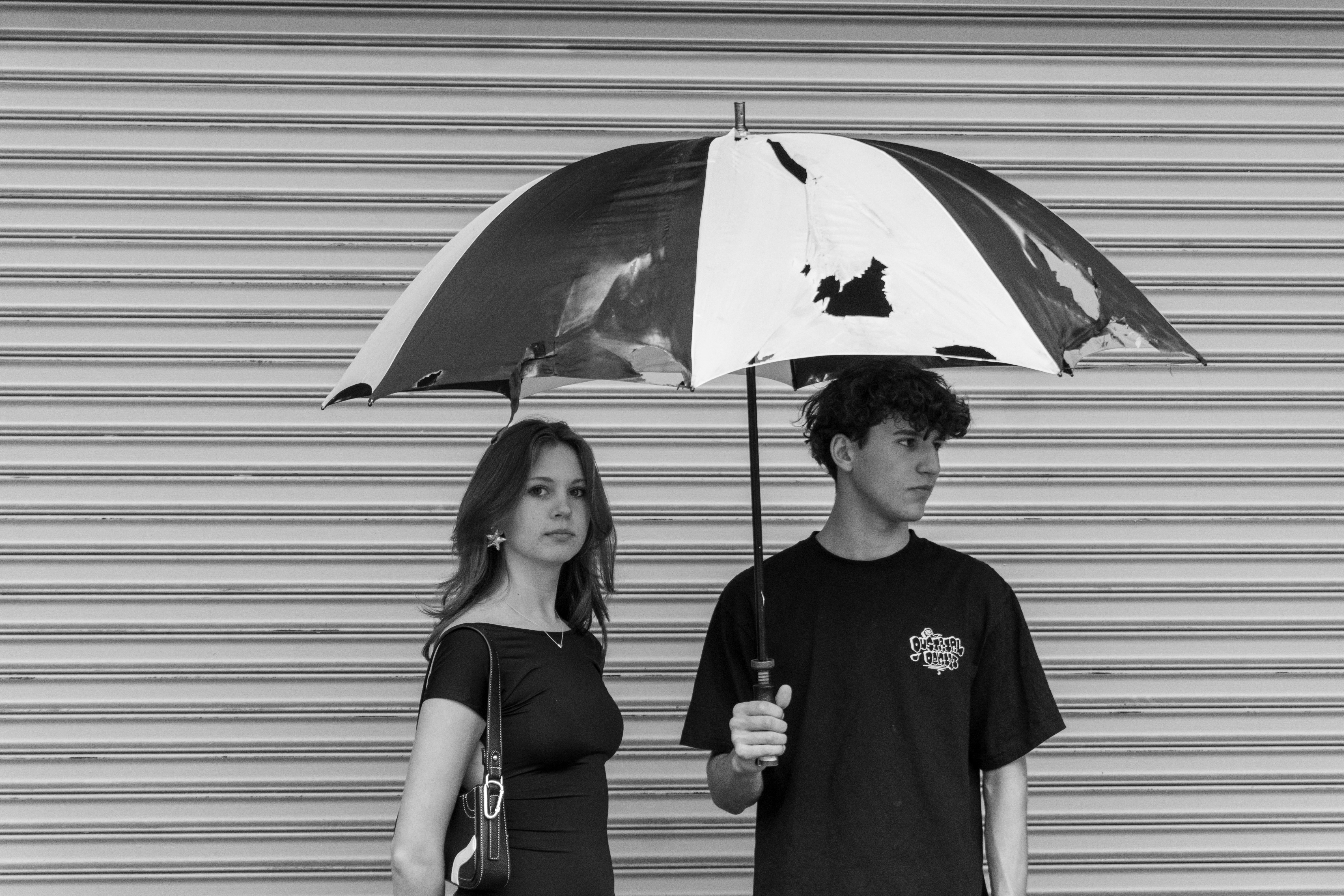A man and a woman standing under an umbrella