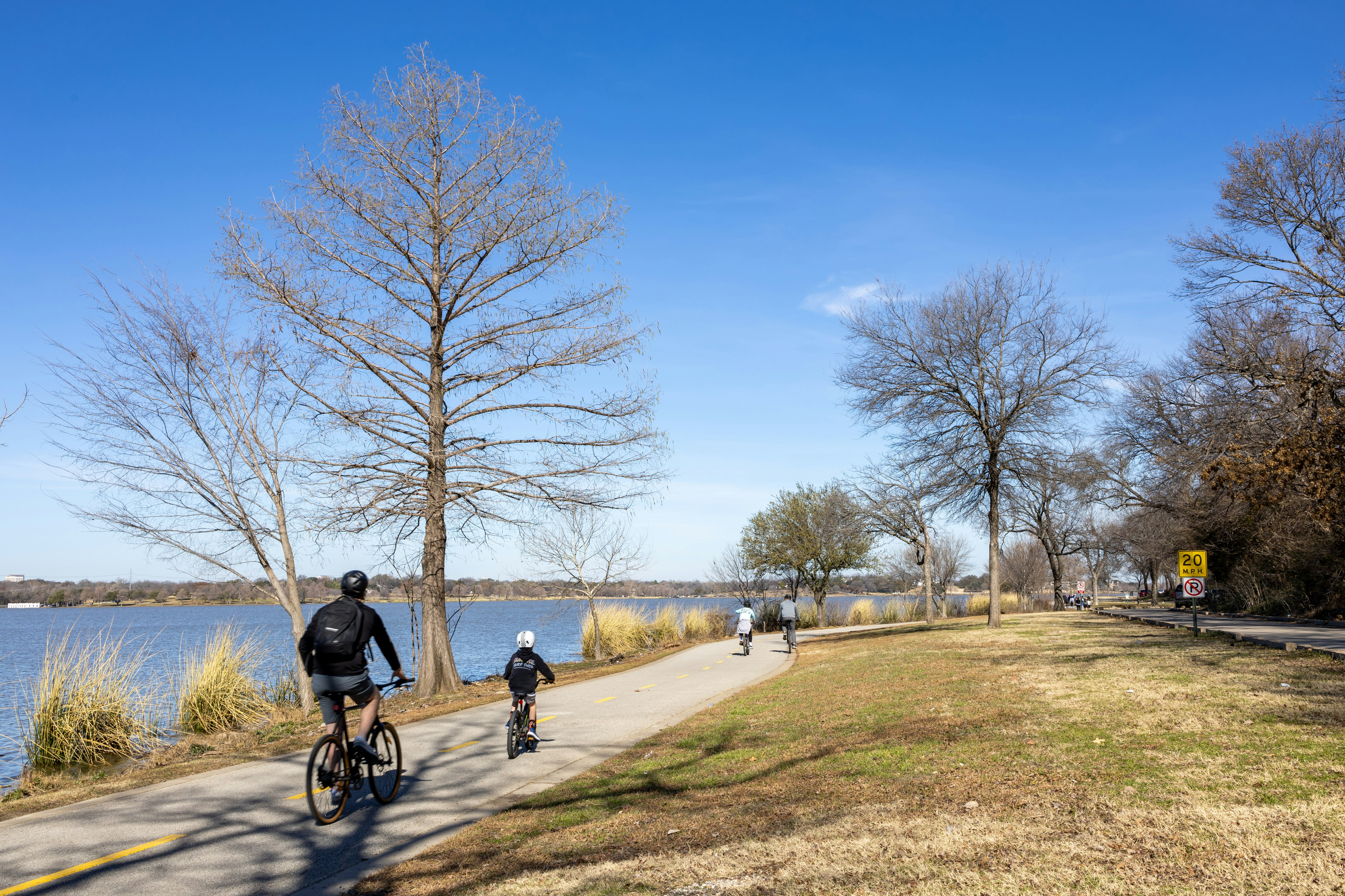 Cyclist riding a path beside White Rock Lake, Dallas