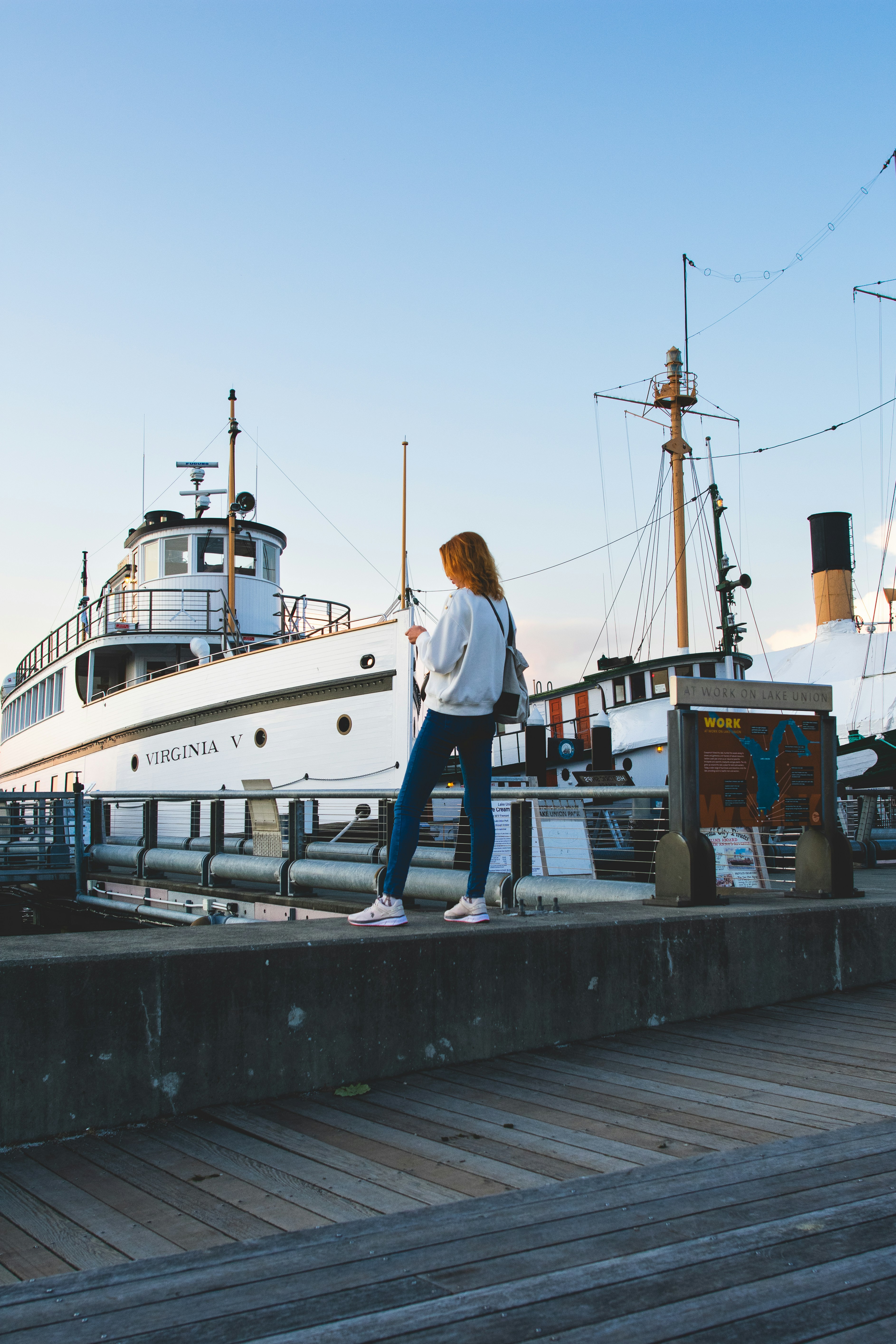 A woman standing on a dock next to a boat