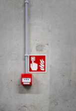 A red and white fire extinguisher sign on a concrete wall